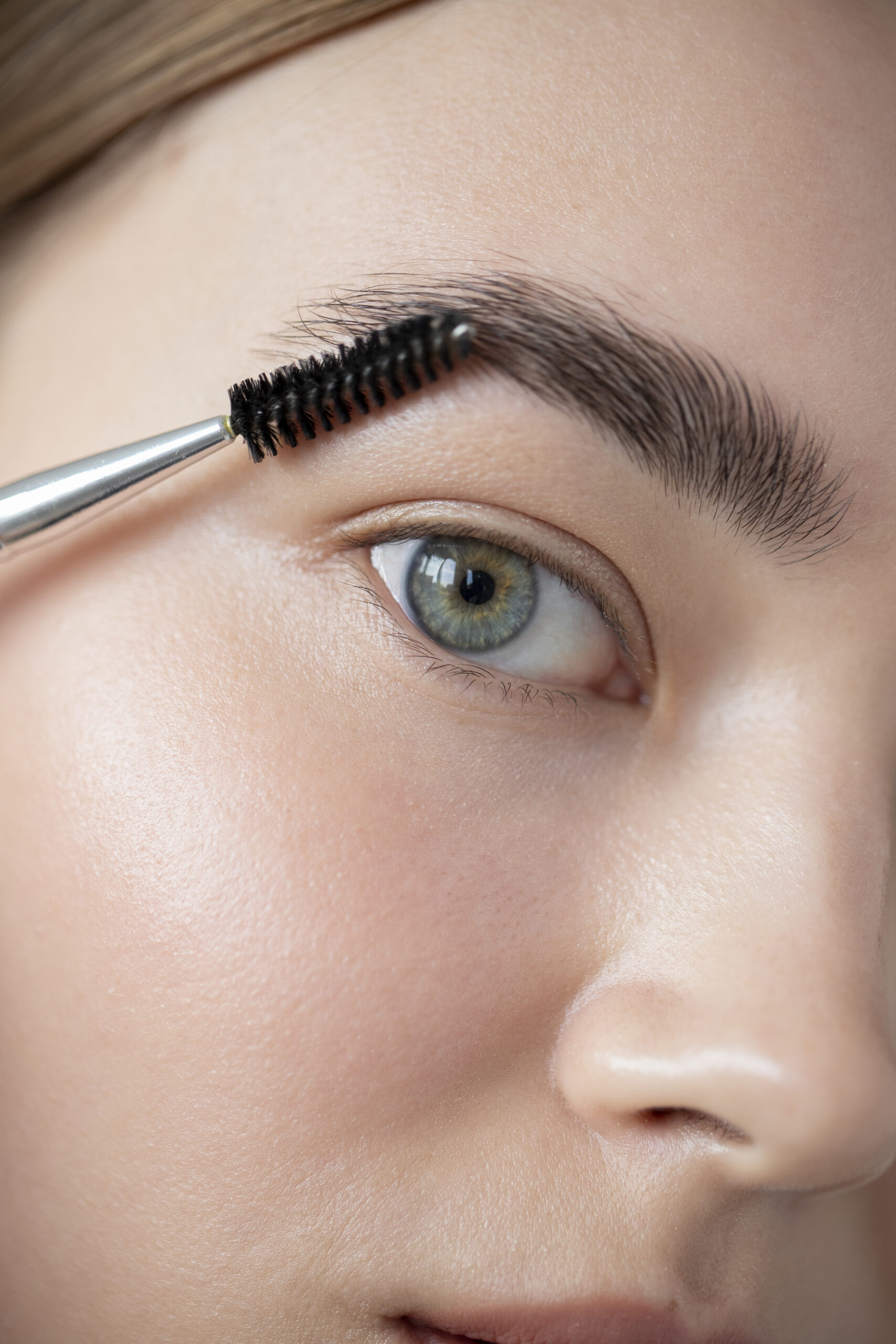 portrait-beautiful-woman-with-clear-skin-brushing-her-eyebrows